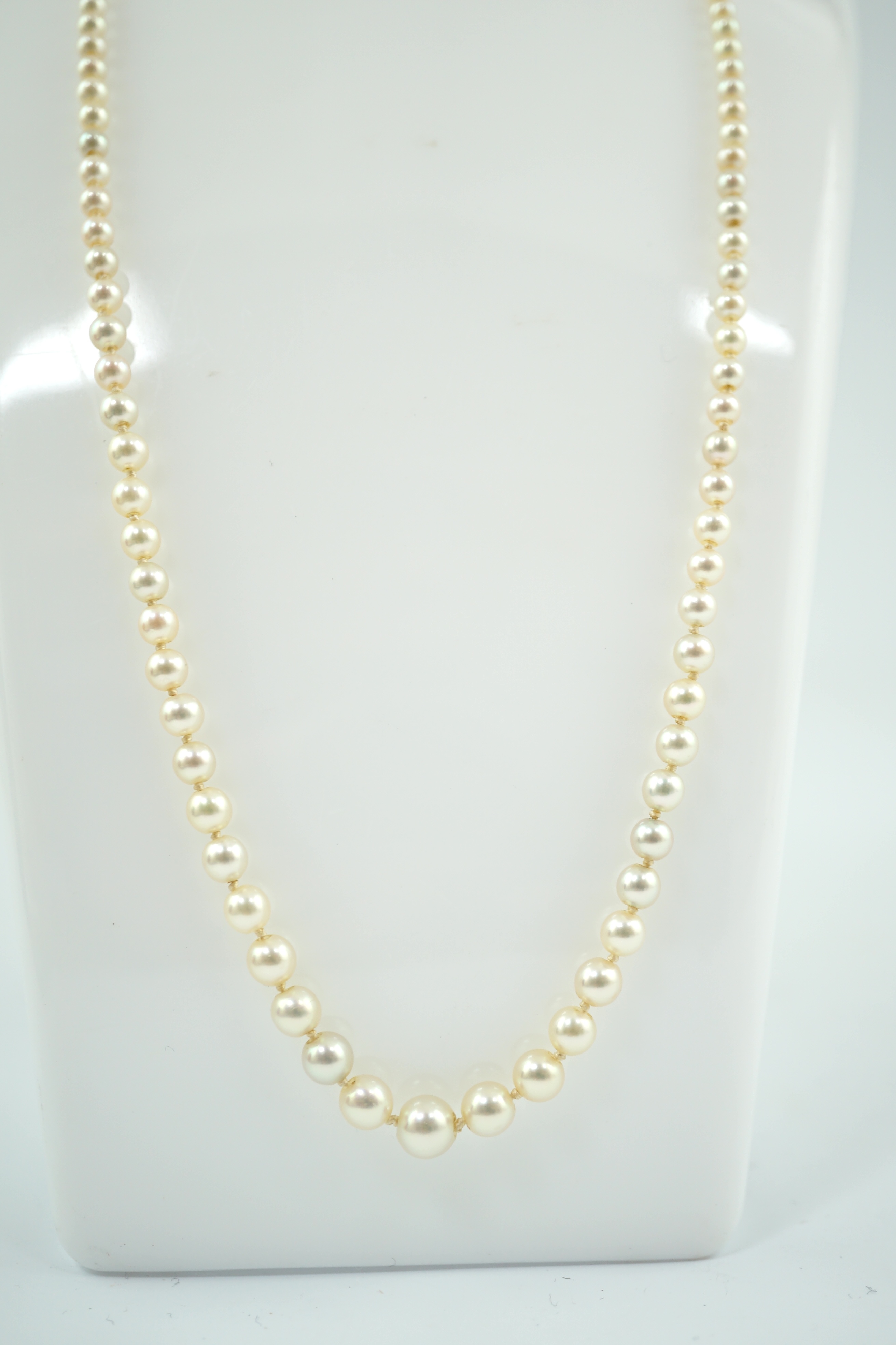 A single strand graduated cultured pearl necklace, with emerald and diamond cluster set gold clasp